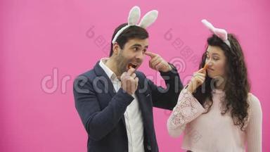 年轻夫妇的粉红色背景很漂亮。 在这段时间里，他们穿着杂乱的耳朵。 看着对方